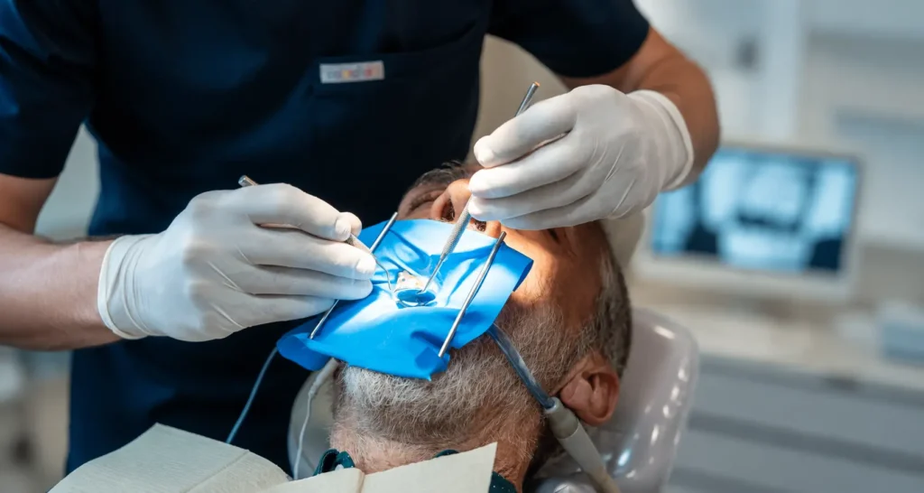 Odontólogo realizando una endodoncia con aislamiento de dique de goma